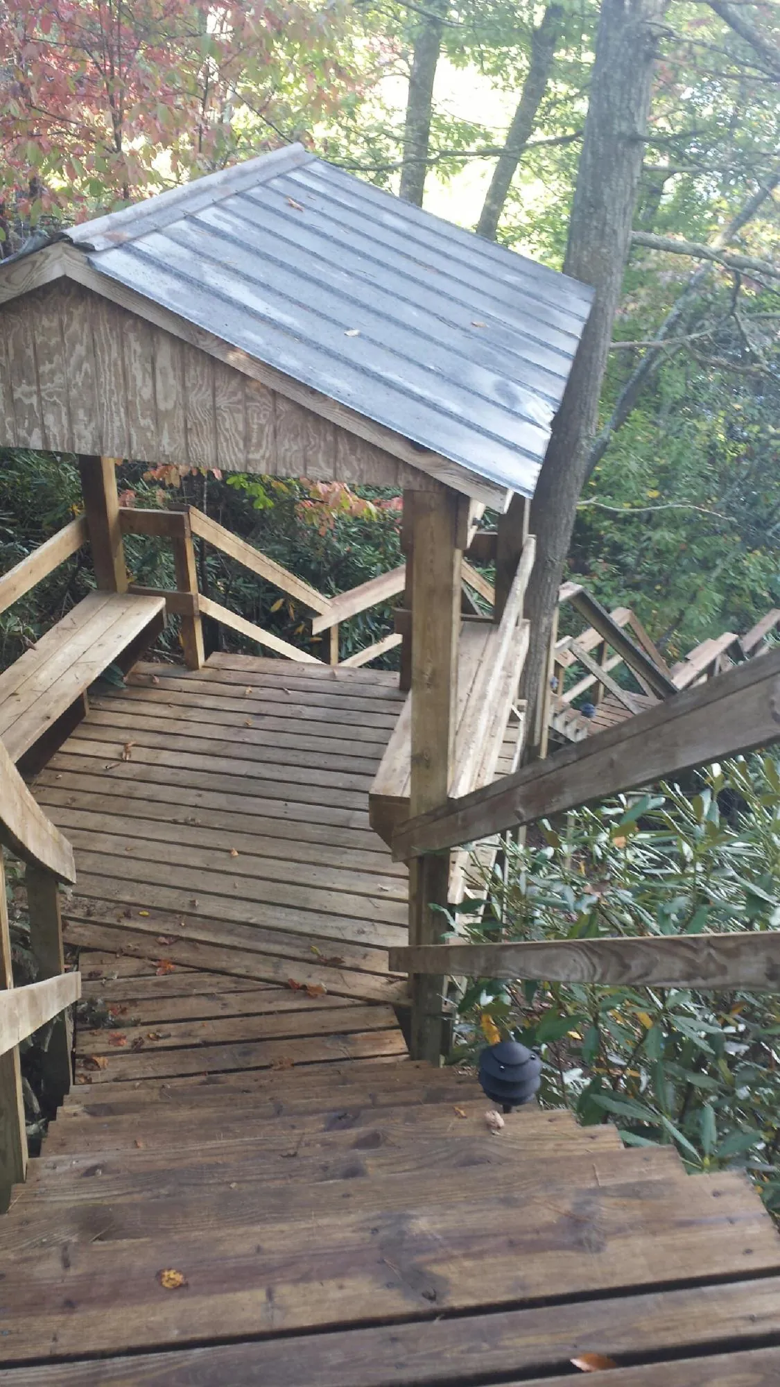Metal roofed shelter over wooden steps on a wooded walkway — Skylight Repair & Installation work by our crew in Galloway