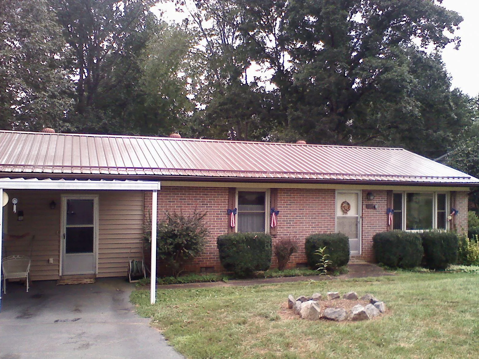 Bronze metal roof and carport on a brick ranch home — Roof Repair work by our crew in Galloway